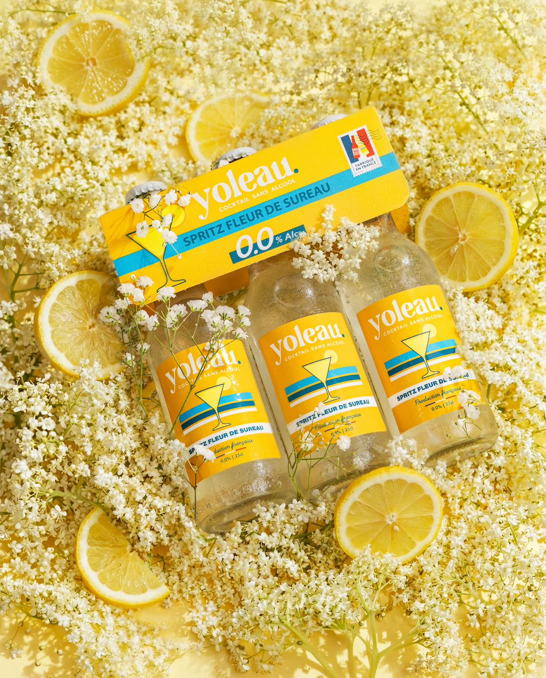 Fleurs de sureau blanches fraîches à côté d'un pack de spritz Fleur de sureau yoleau