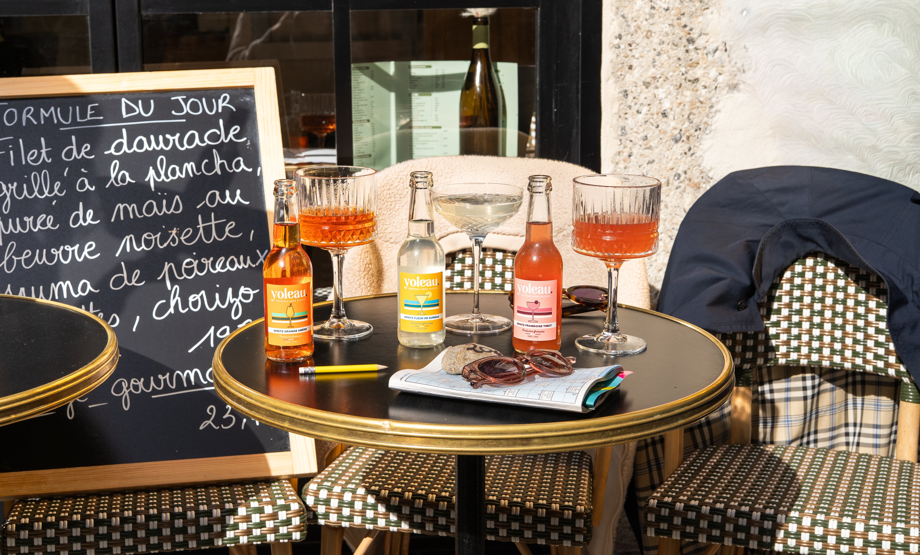 Spritz Orange amère Yoleau, spritz Fleur de Sureau Yoleau, et spritz Framboise Timut Yoleau, dans des verres en terrasse