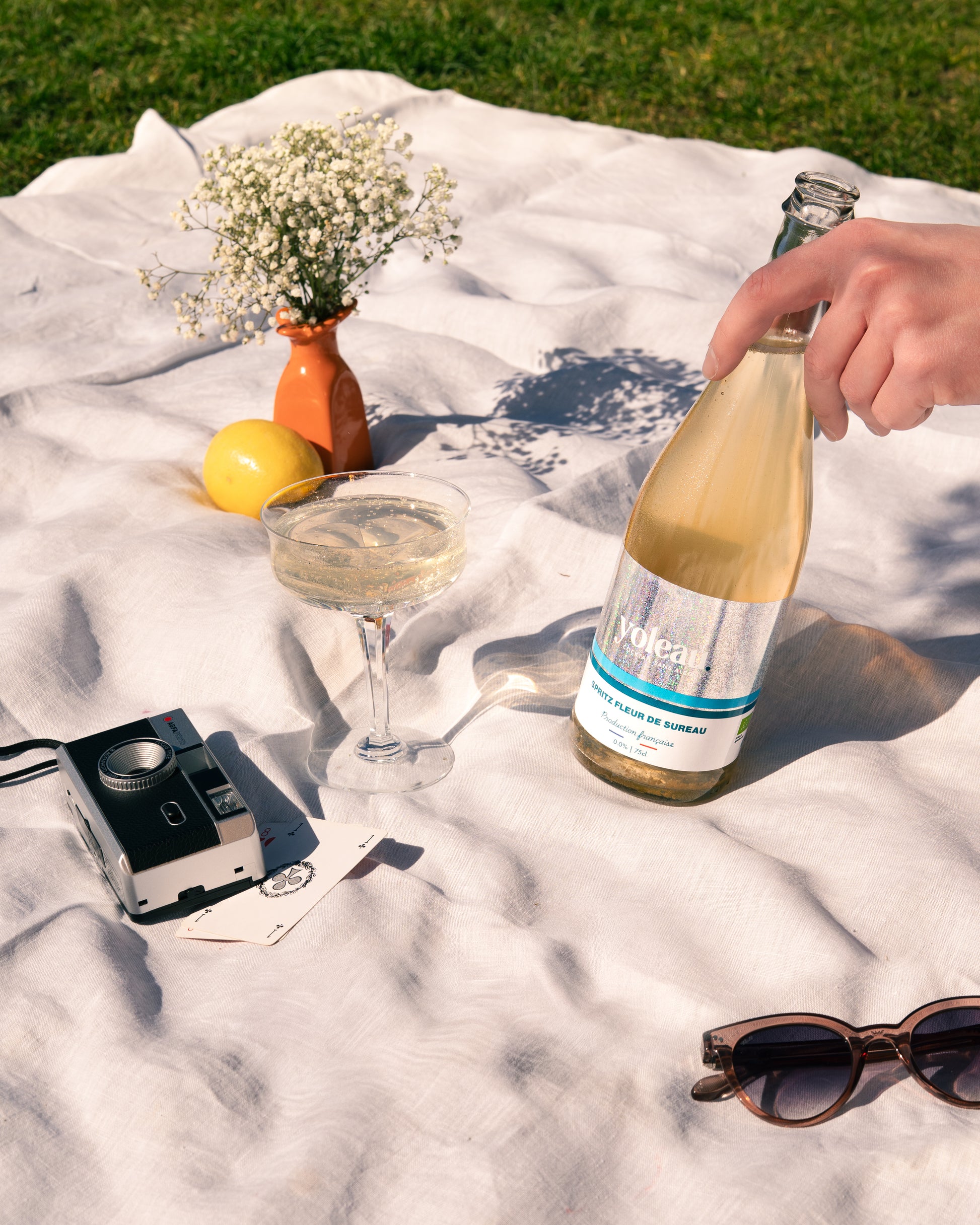 Spritz Fleur de sureau Yoleau, dans verre à cocktail, apéro sur l'herbe au soleil